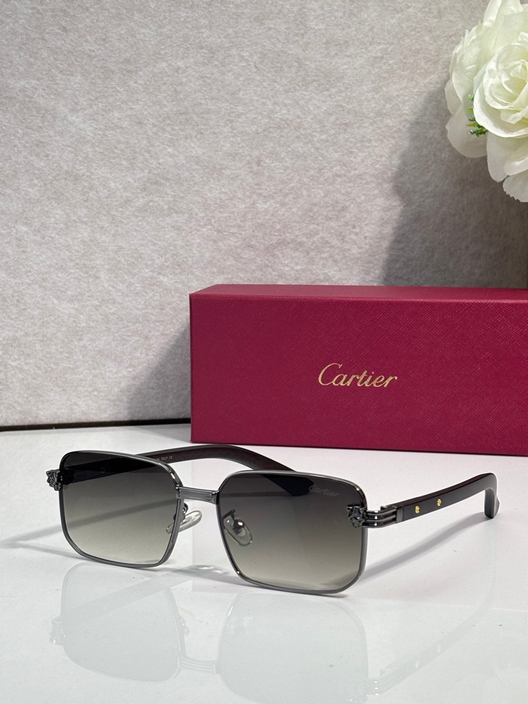 Cartier sunglasses with black frame and dark lenses, thick front with metal accents