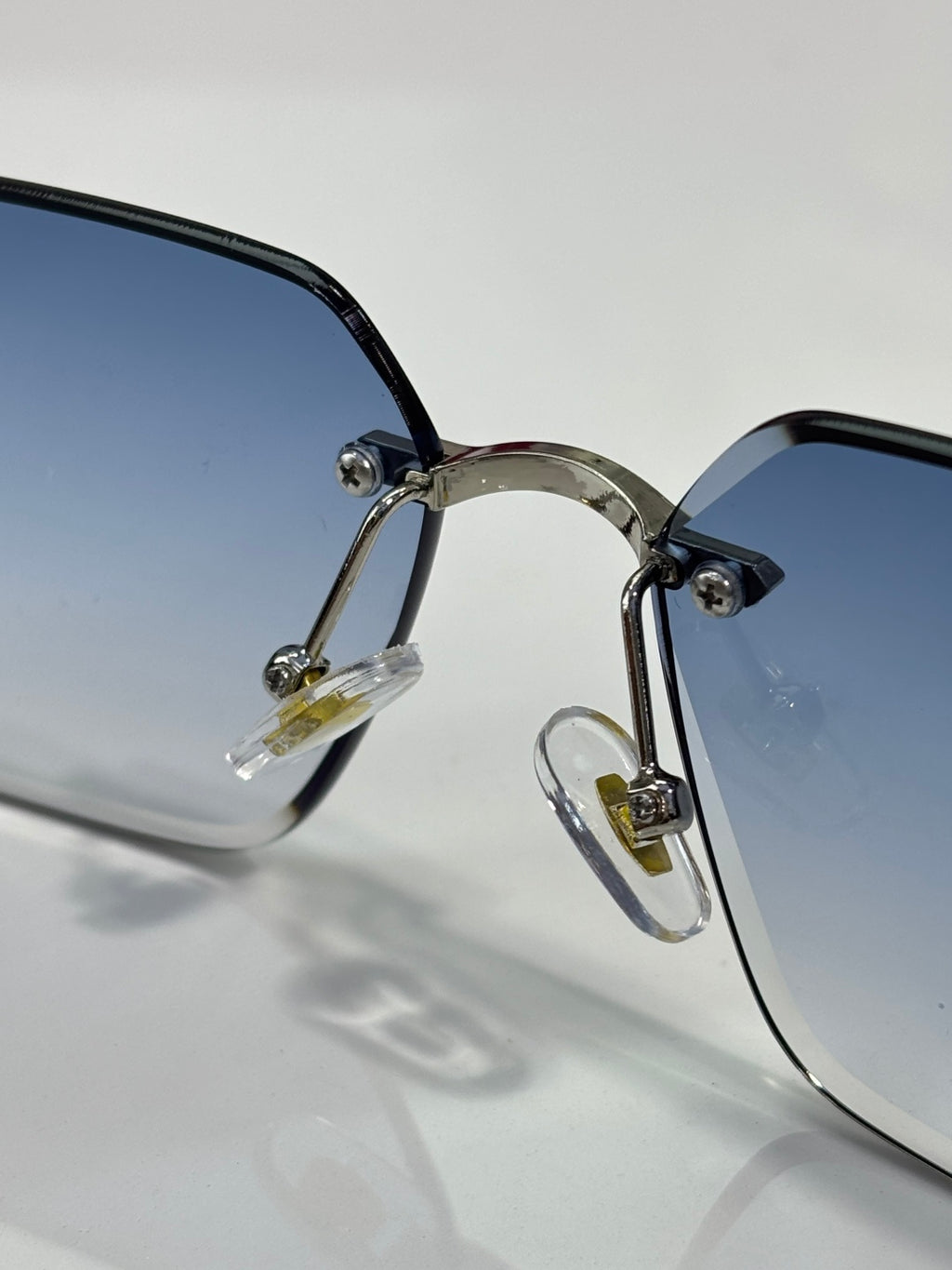 Cartier sunglasses close-up with blue-tinted lenses and gold-tone metal hinges