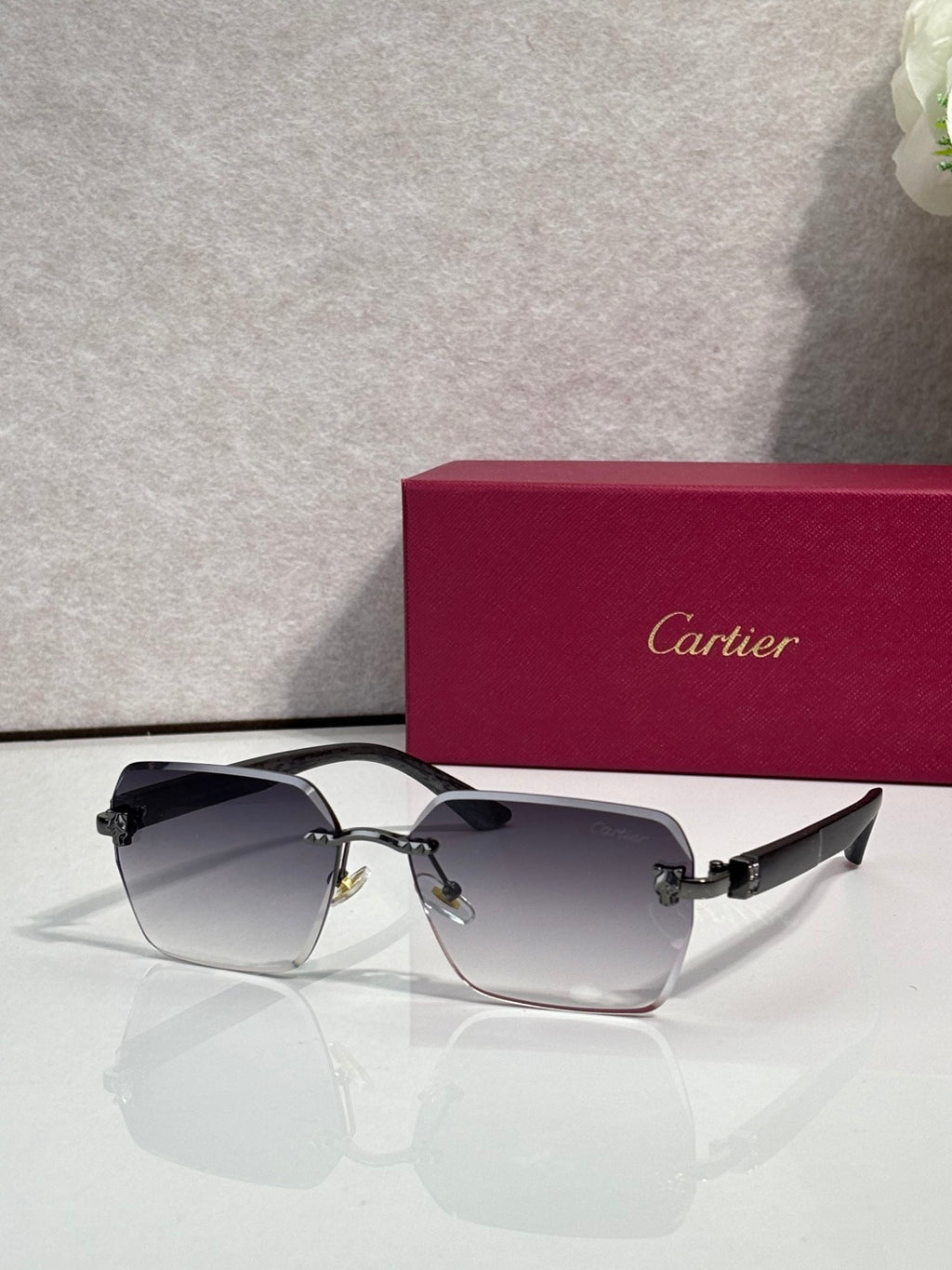 Cartier sunglasses with light blue lenses, black frame, and gold-tone hinges
