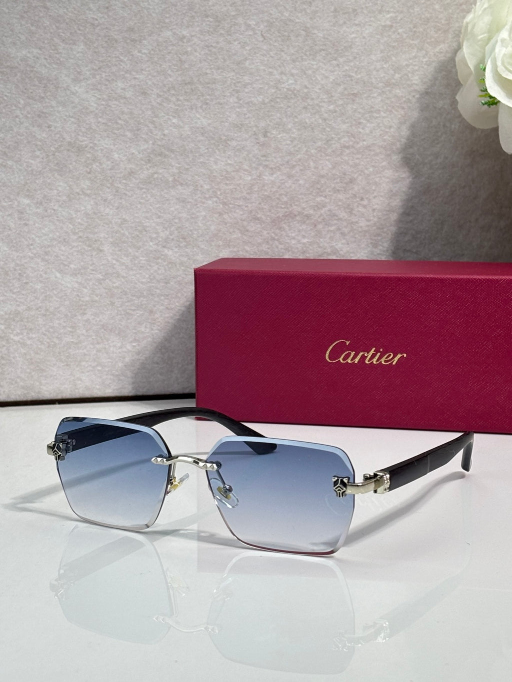 Cartier sunglasses with pale blue lenses and black frame, gold-tone accents