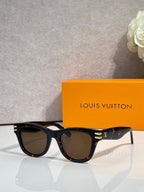 Louis Vuitton sunglasses with black frames, dark lenses, and gold temple detailing