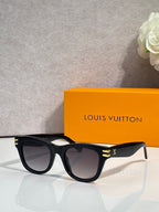 Louis Vuitton sunglasses with black frames, dark lenses, and gold temple detailing