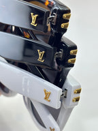 Louis Vuitton logo hinges on stacked black and white sunglasses frames with gold hardware