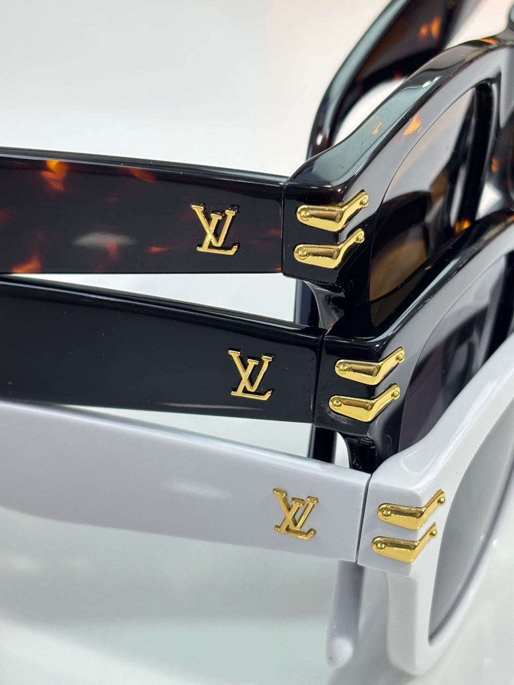 Gold Louis Vuitton logo hinges on black and white sunglasses frames