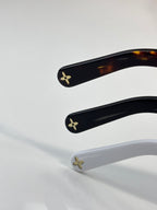 Sunglasses temples with gold flower logos on black and white frames