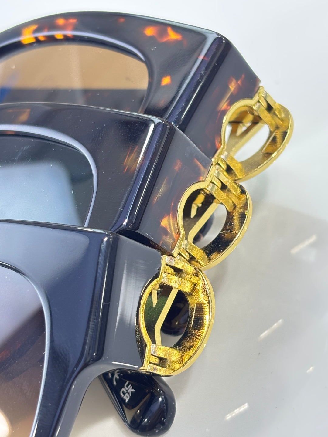 Gold LV emblem and temple tip on dark sunglasses with reflective lenses
