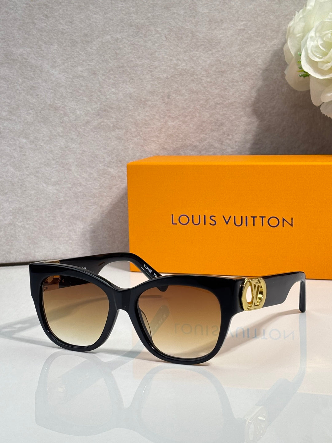 Dark tortoiseshell sunglasses with round lenses and gold LV logo on the arm