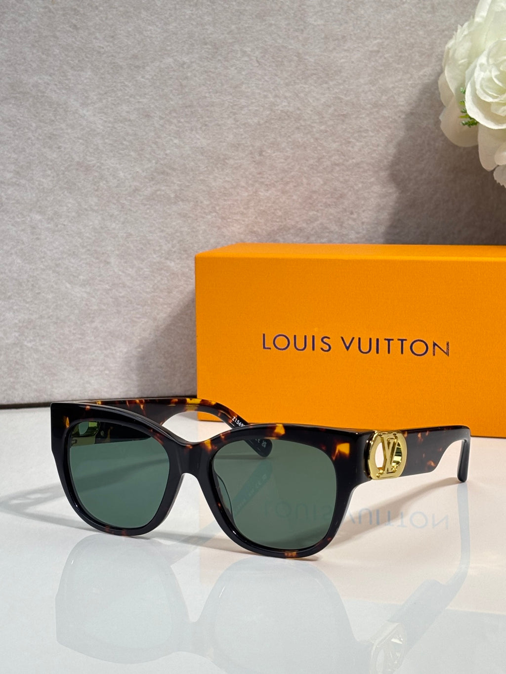 Dark tortoiseshell sunglasses with tinted lenses and gold LV side emblem