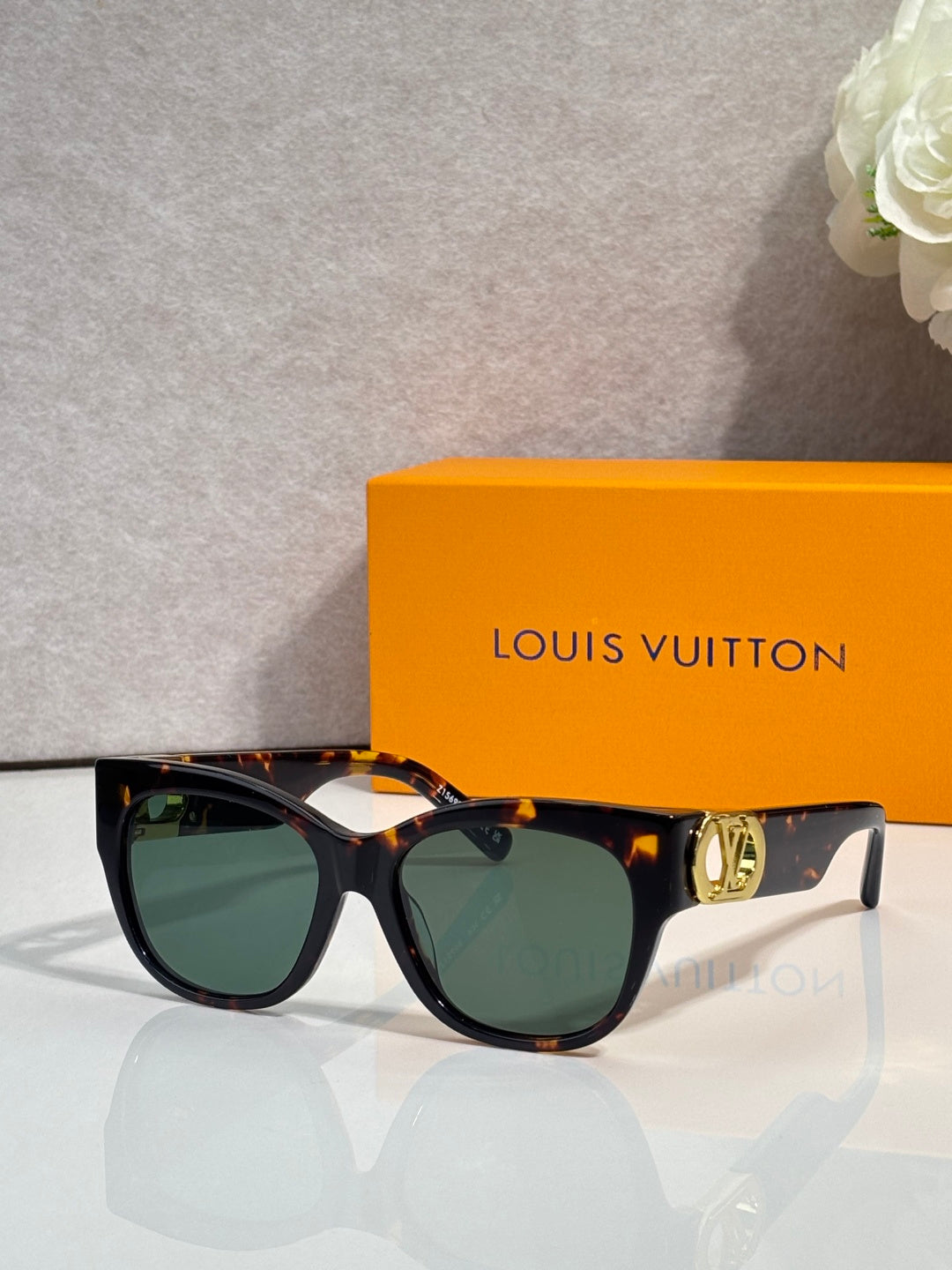 Dark tortoiseshell sunglasses with tinted lenses and gold LV side emblem