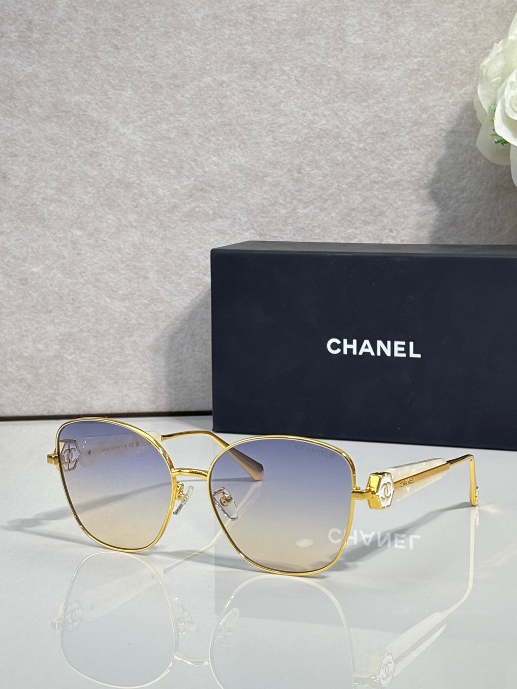 Chanel sunglasses with gold-tone frame and light blue tinted lenses