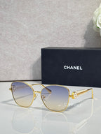 Chanel sunglasses with gold-tone frame and light blue tinted lenses
