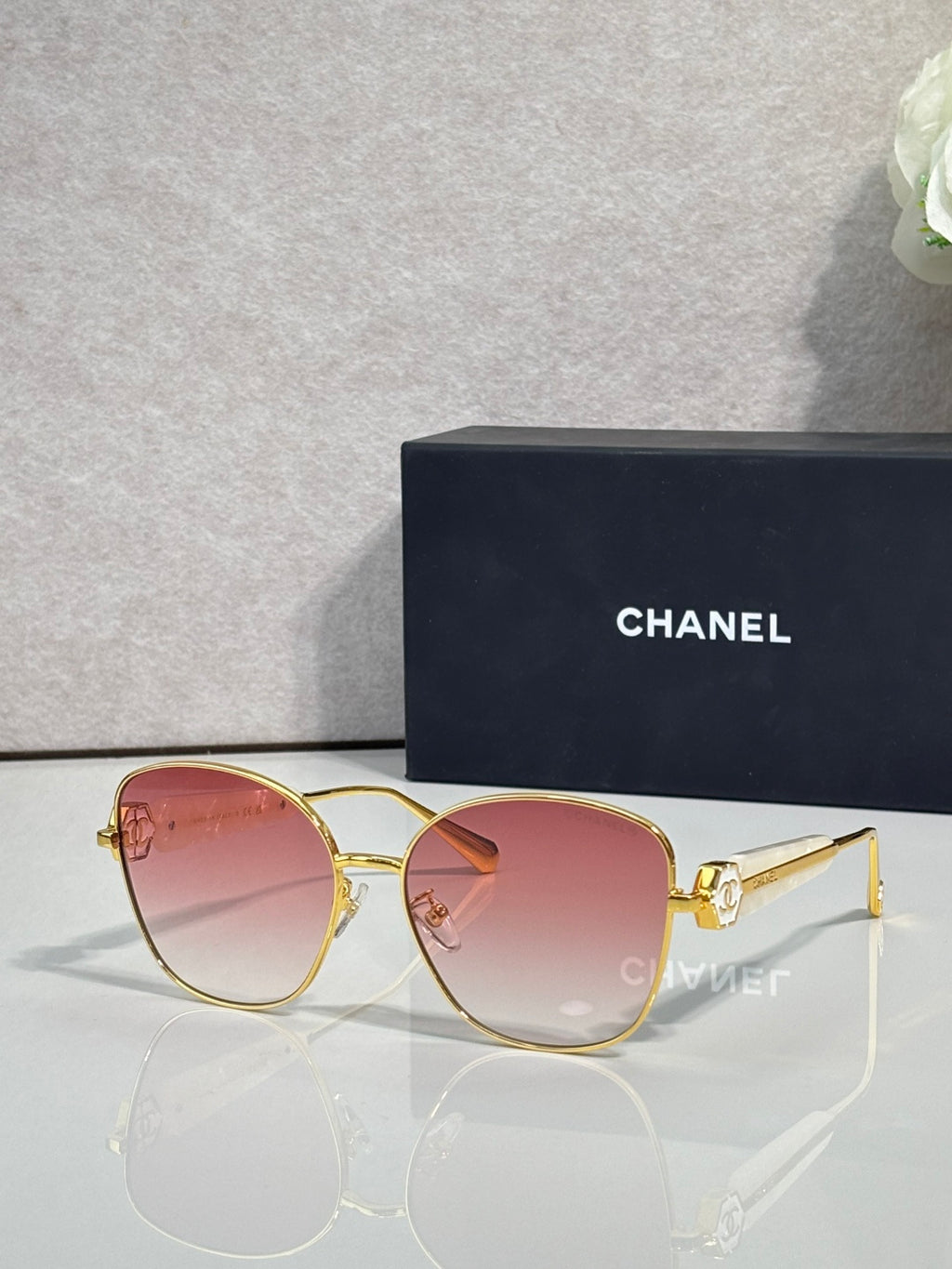 Chanel sunglasses with gold-tone frame and pink tinted lenses