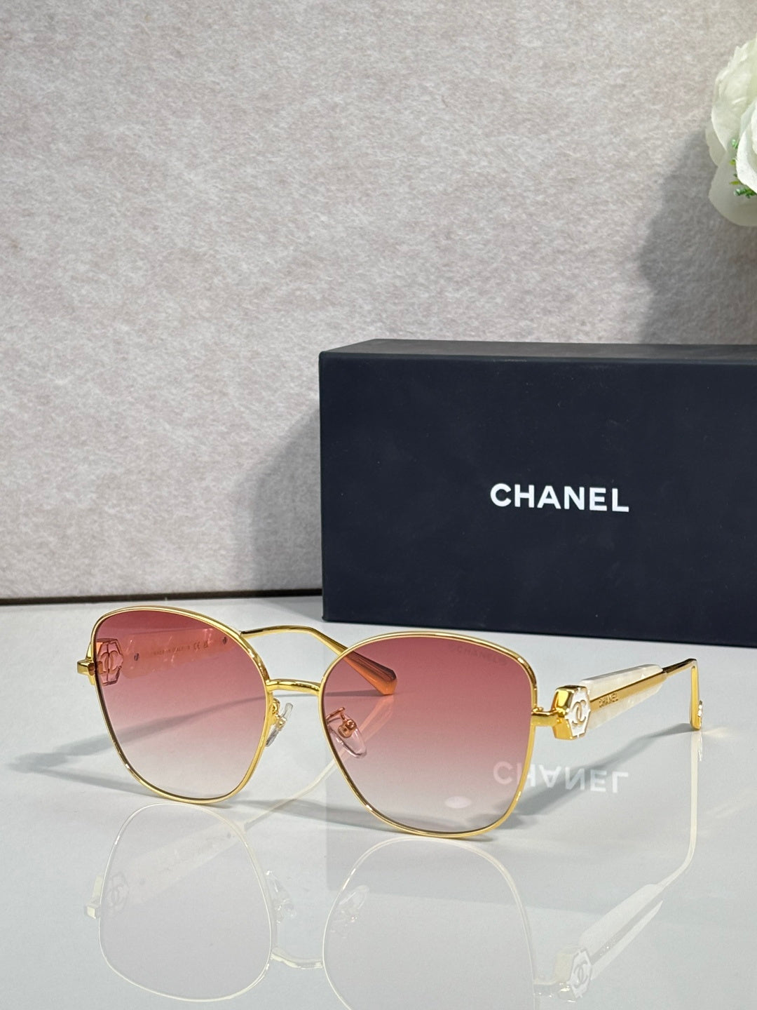Chanel sunglasses with gold-tone frame and pink tinted lenses