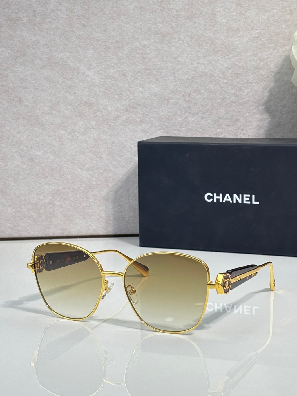 Chanel sunglasses with gold-tone frame and light gray tinted lenses