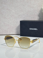 Chanel sunglasses with gold-tone frame and light gray tinted lenses