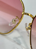 Sunglass frame detail with gold-tone arms and clear nose bridge