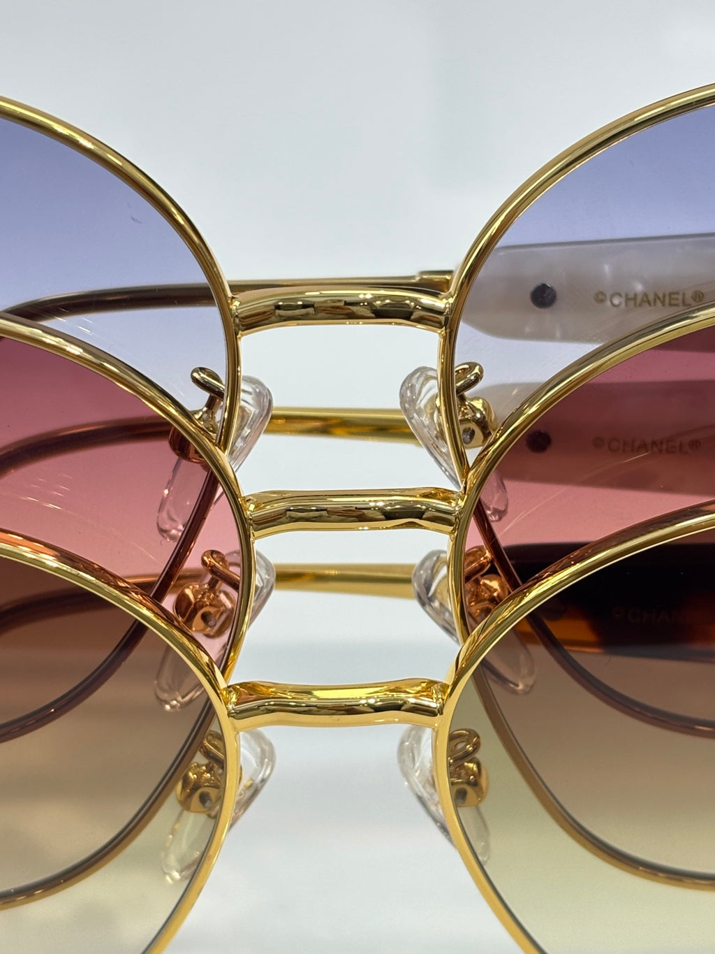 Sunglasses lens and frame close-up with gold-tone rims and colored tint