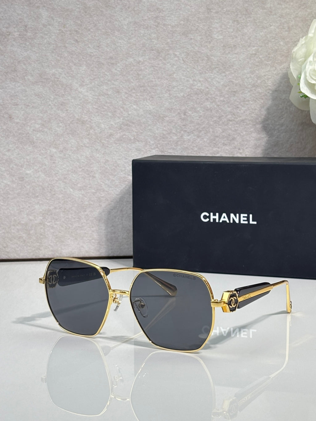 Gold-tone square sunglasses with dark lenses and gold temple accents