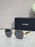 Gold-tone square sunglasses with dark lenses and gold temple accents