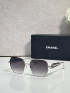 Gold-tone square sunglasses with dark smoke lenses and metal hinge detail