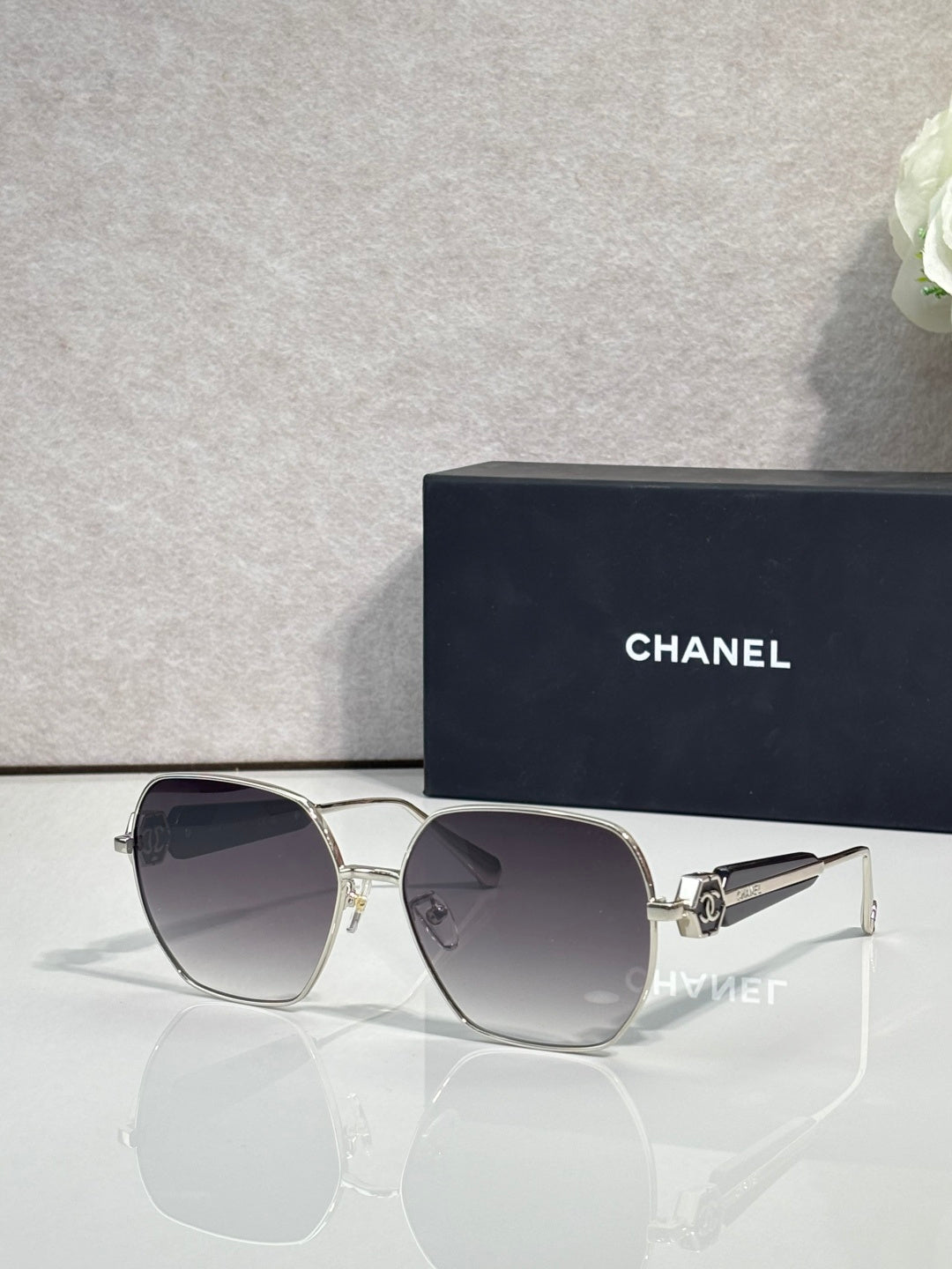 Gold-tone square sunglasses with dark smoke lenses and metal hinge detail