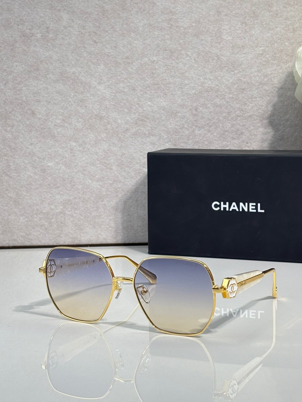 Gold-tone square sunglasses with clear nose bridge and dark blue lenses