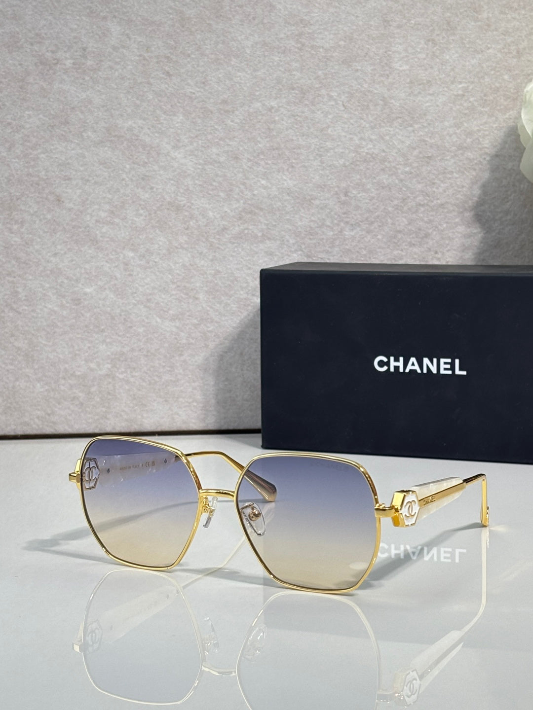 Gold-tone square sunglasses with clear nose bridge and dark blue lenses
