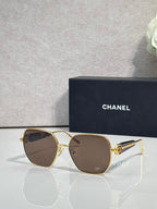 Gold-tone square sunglasses with brown lenses and emblem detail on temples