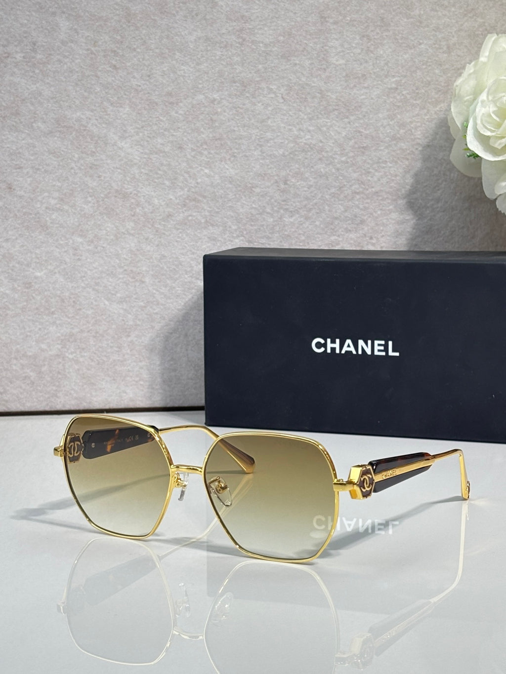 Gold-tone square sunglasses with light gradient lenses and metal hinge detail