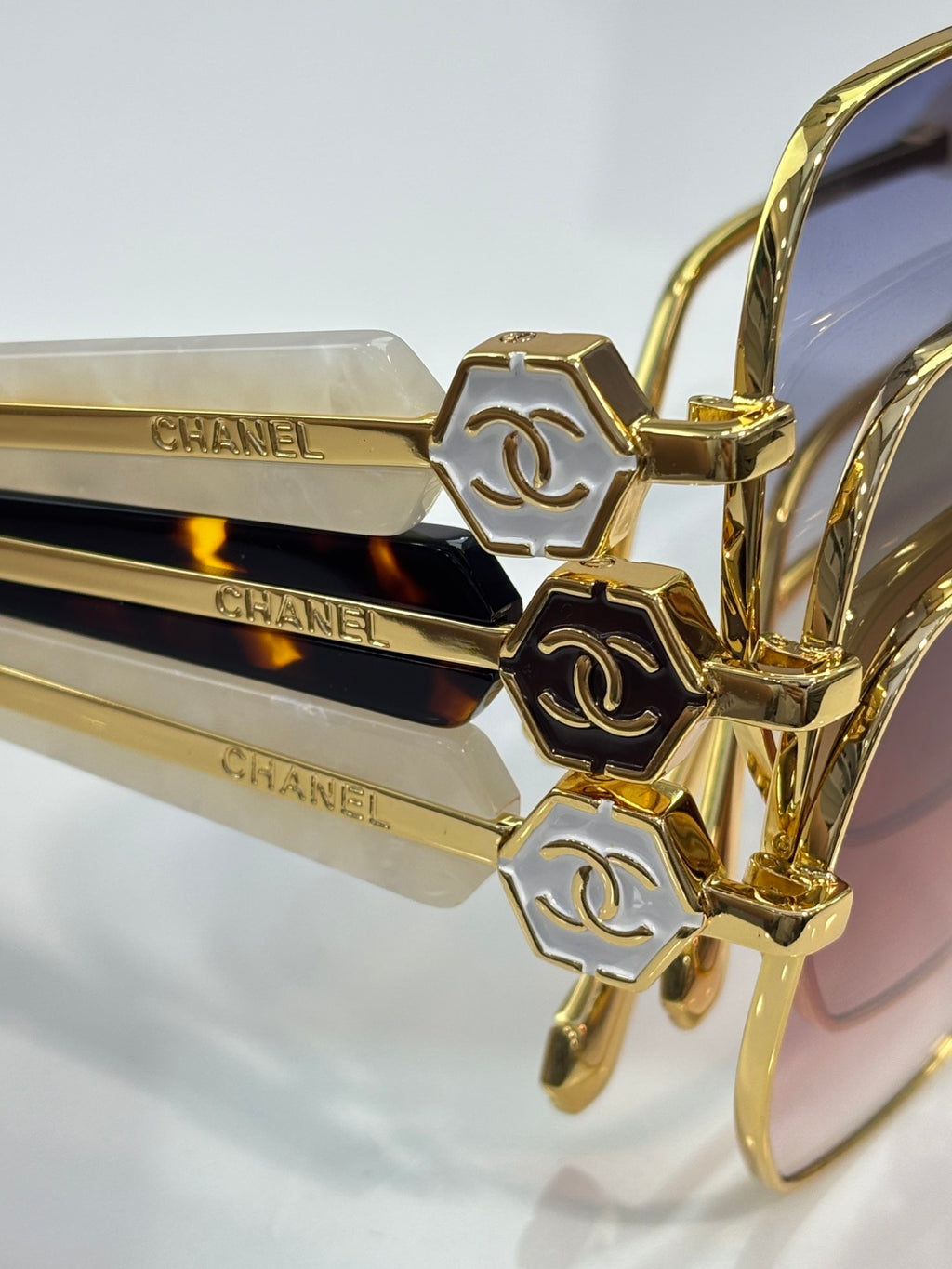Gold-tone eyeglass frame close-up with engraved CHANEL temple accents and hinges