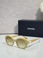 Chanel round sunglasses with light green frames and tan tinted lenses, gold-tone arms