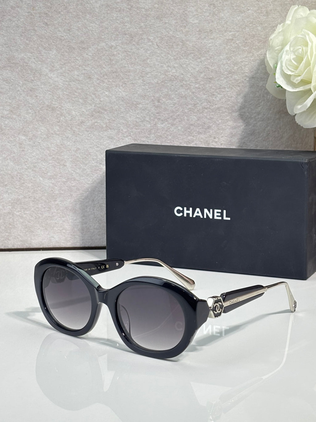 Chanel cat-eye sunglasses with black frames and dark lenses, gold-tone accents