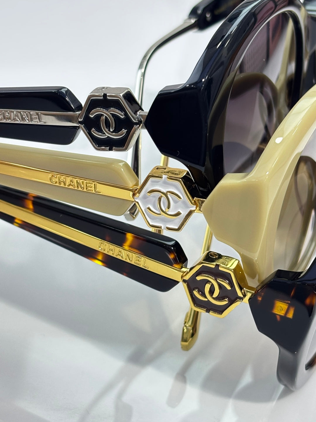 Chanel sunglasses close-up with gold-tone logo hardware on dark and yellow frames