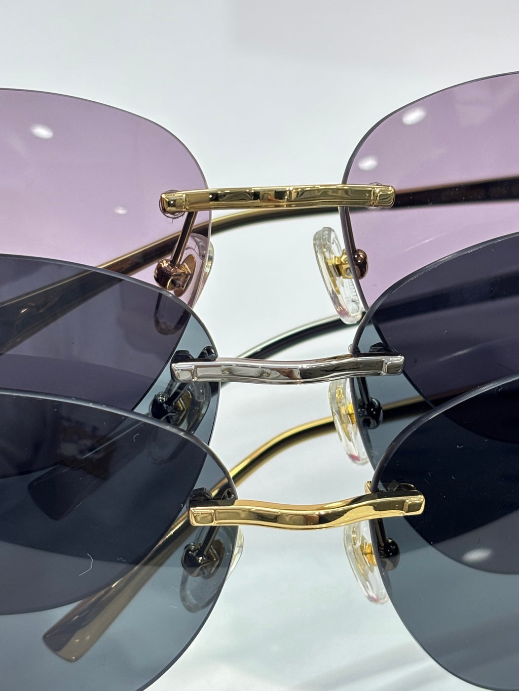 Cartier sunglasses close-up: gold frame with purple-tinted lenses and clear studs