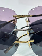 Cartier sunglasses close-up: gold frame with purple-tinted lenses and clear studs