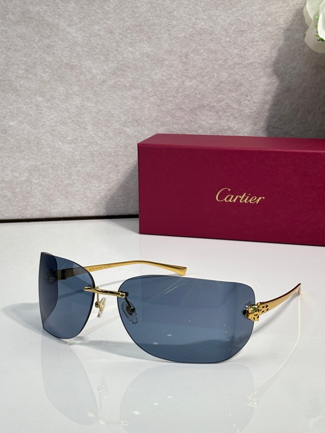 Cartier sunglasses with gold frame and blue-tinted shield lenses