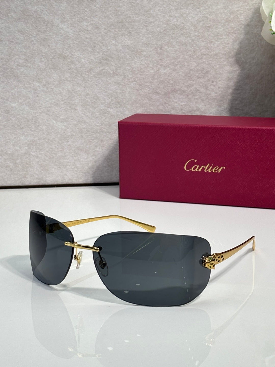Cartier sunglasses with gold frame and dark charcoal shield lenses