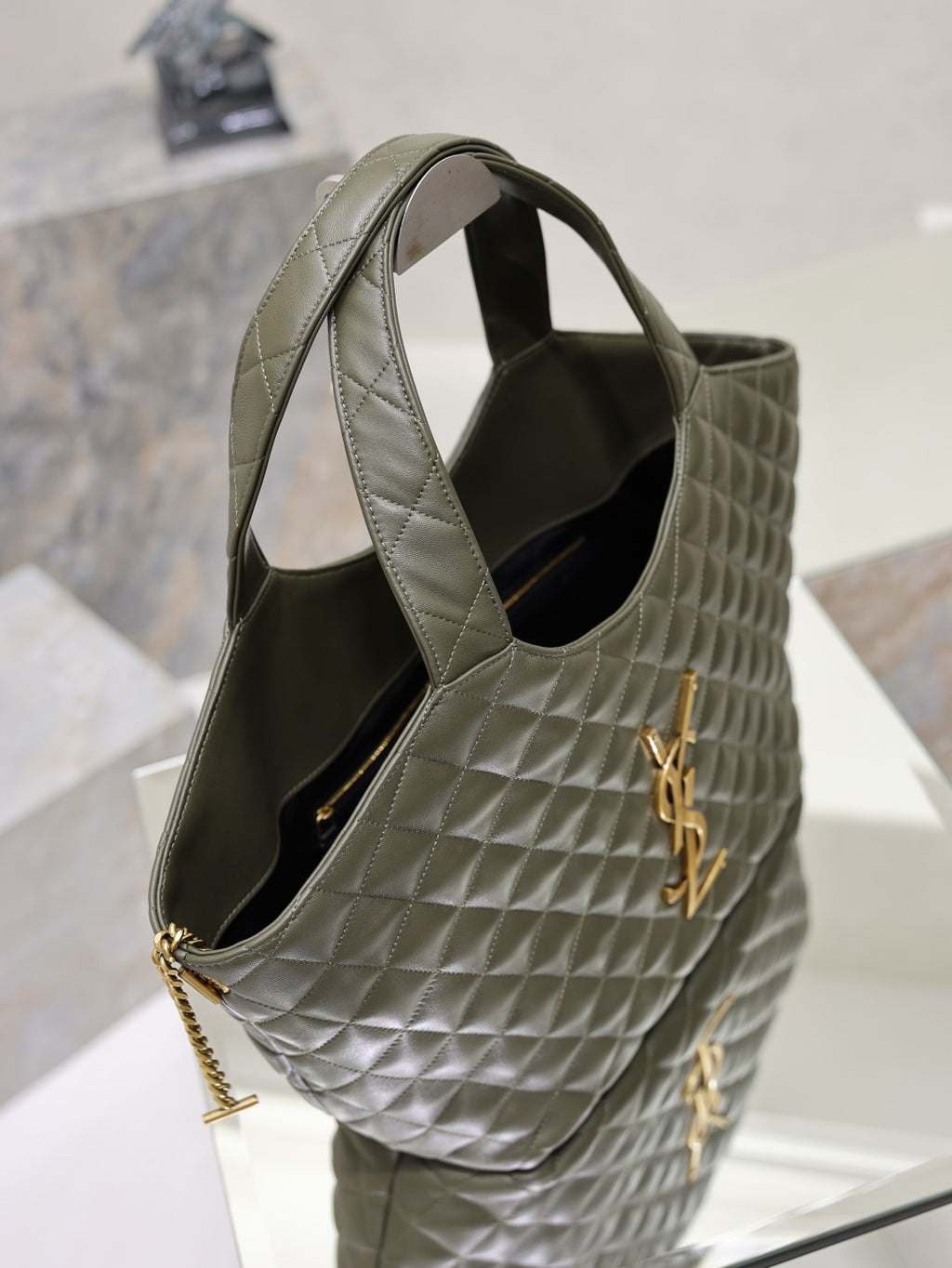 YSL quilted olive green tote bag with open top, chain strap, and black interior