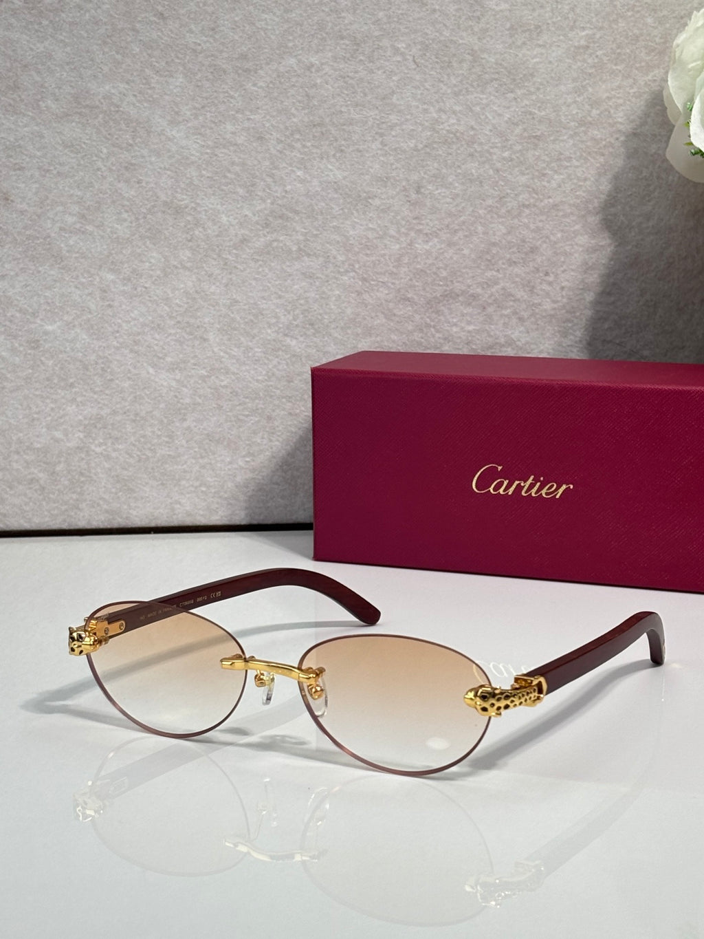 Cartier eyeglasses with dark brown frame and pale yellow lenses, gold temple details