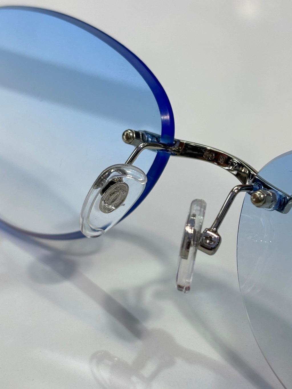 Cartier eyeglasses close-up: blue temple with metal hinge and clear lens