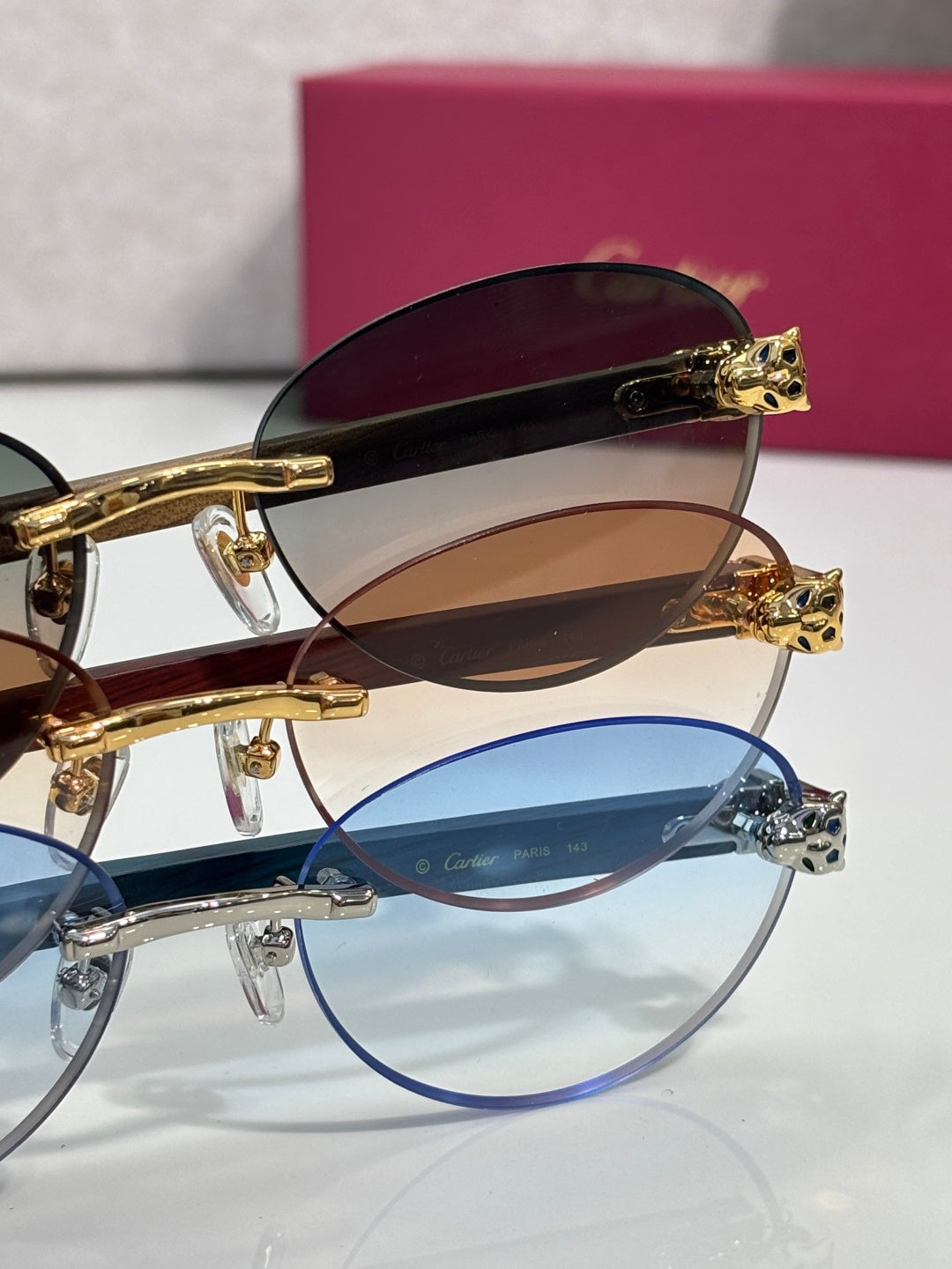 Cartier eyeglasses stack: dark brown and blue frames with tinted lenses