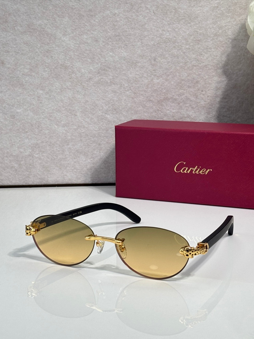Cartier eyeglasses with dark brown frame and pale yellow lenses, gold temple accents