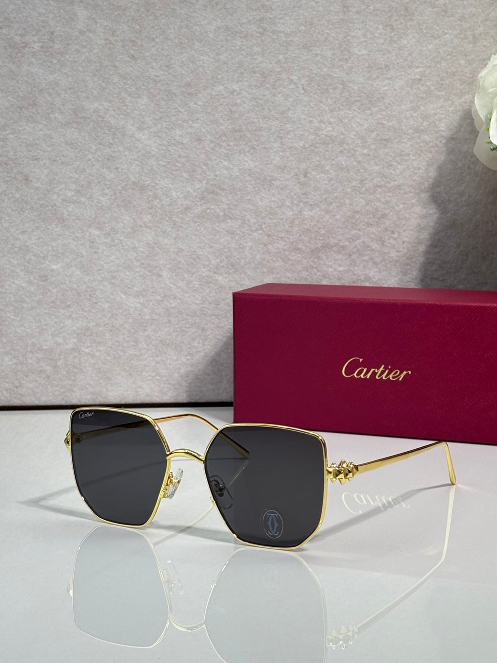 Rectangular sunglasses with gold frame and black mirrored lenses