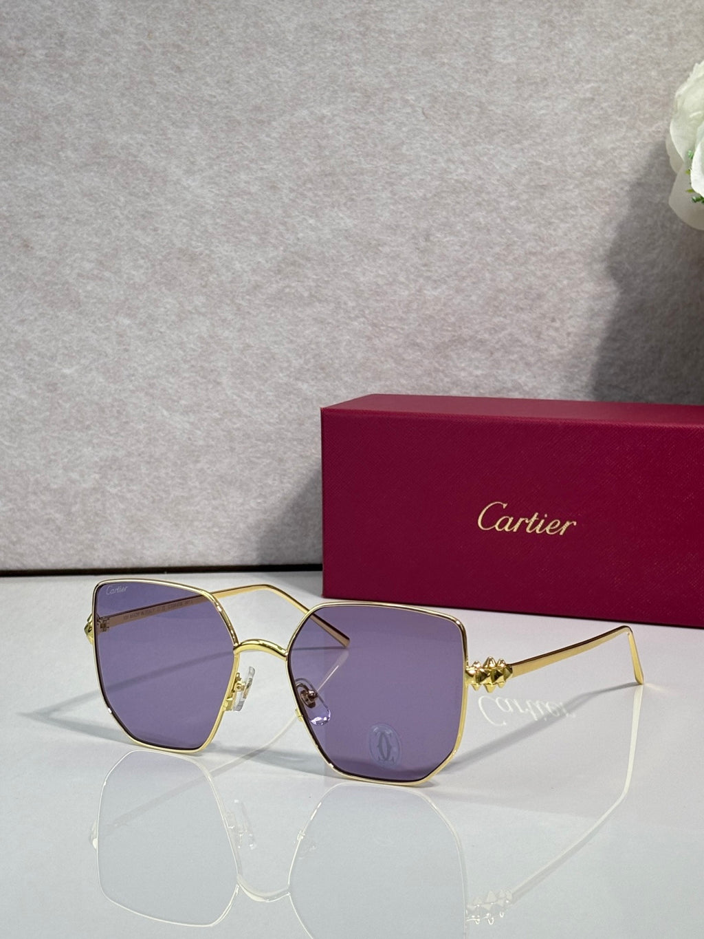 Rectangular sunglasses with gold frame and purple-tinted mirrored lenses