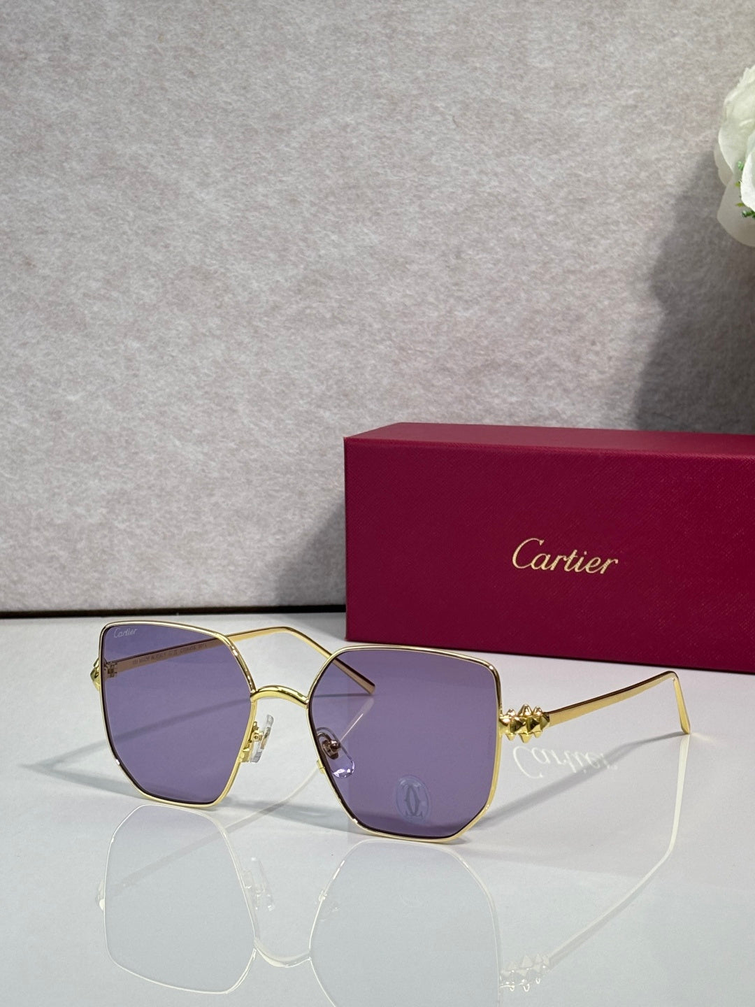 Rectangular sunglasses with gold frame and purple-tinted mirrored lenses