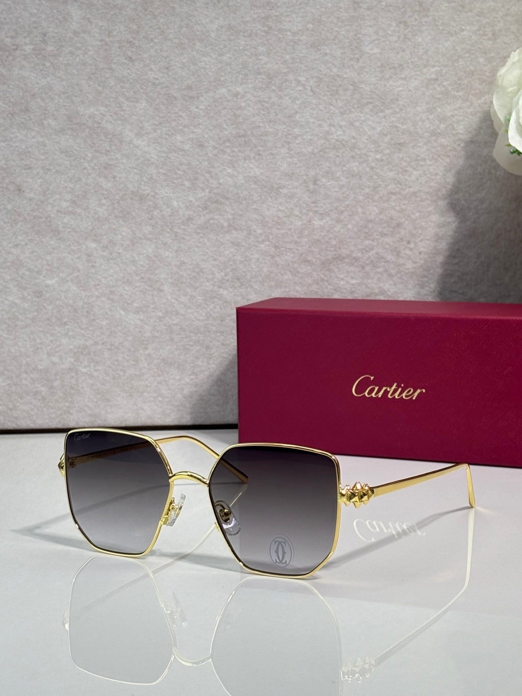 Rectangular sunglasses with gold frame and dark gray mirrored lenses