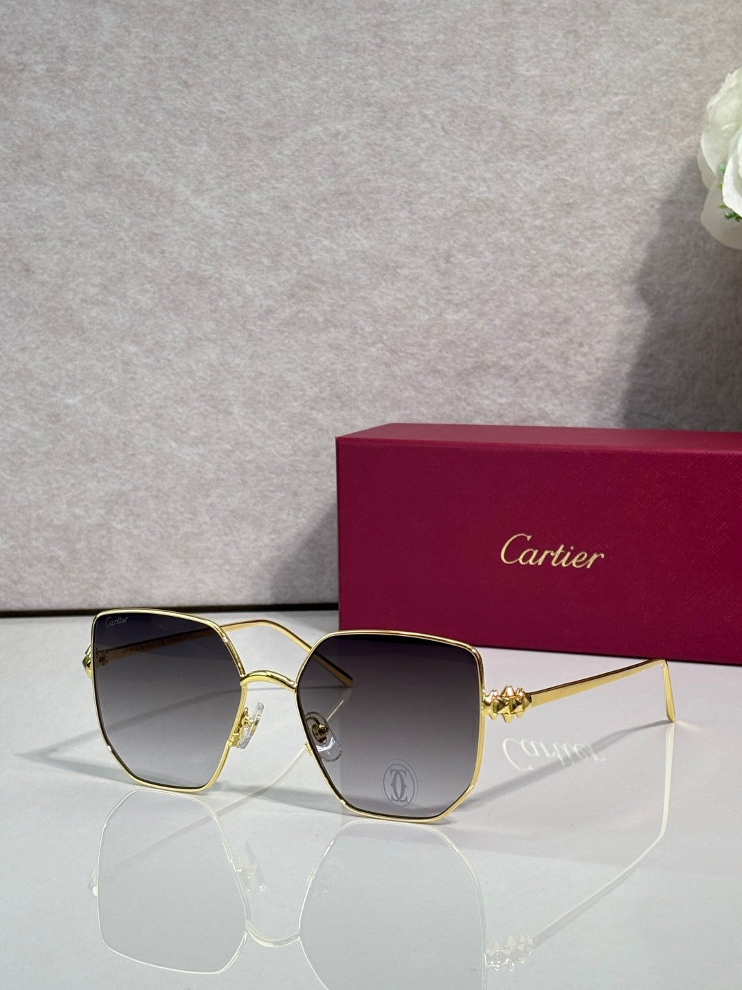 Rectangular sunglasses with gold frame and dark gray mirrored lenses