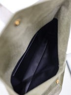 Olive leather clutch bag interior with dark lining and gold snap hardware