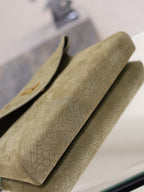 Olive textured leather clutch bag with structured flap and gold monogram on edge