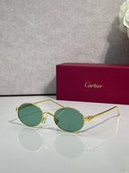 Cartier round metal glasses with gold frame and green-tinted lenses